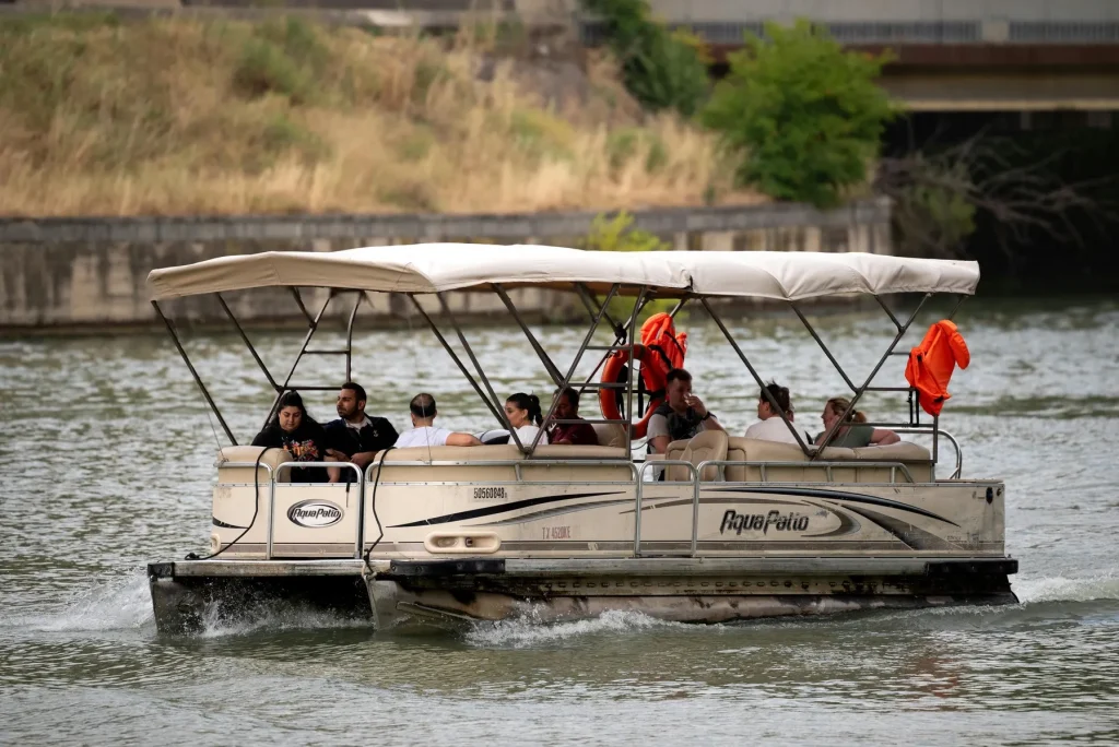 Pontoon boat carrying passengers on calm inland water